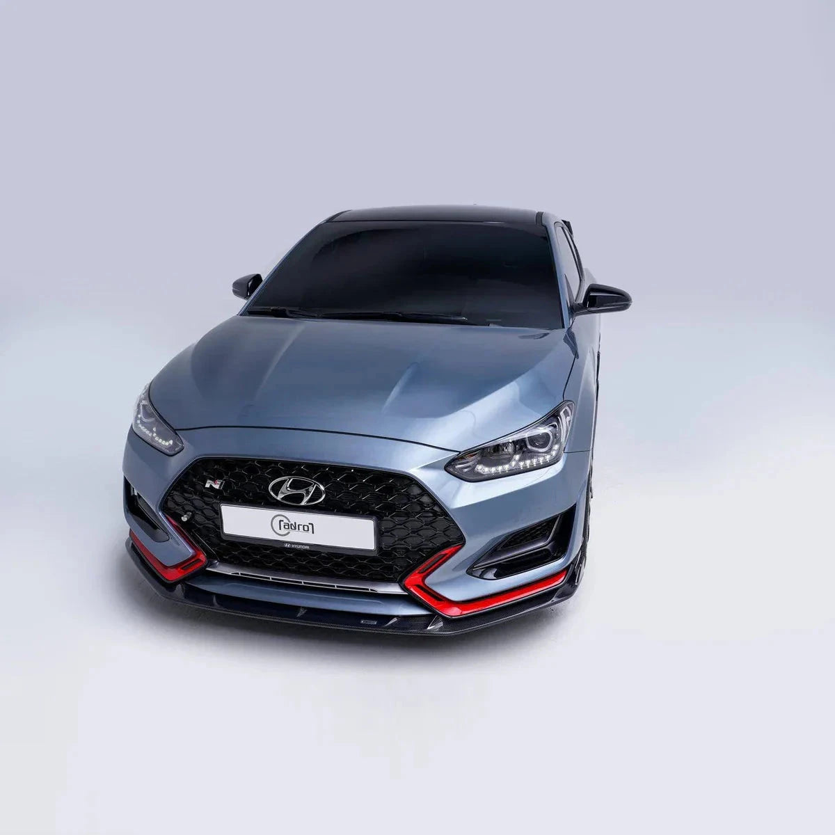 ADRO carbon fiber front lip for Hyundai Veloster N, front view on a plain light background.