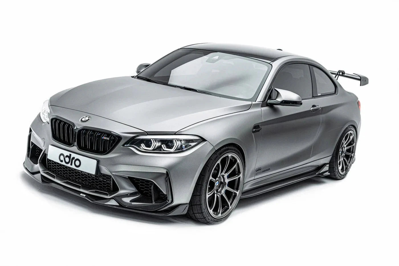 ADRO carbon fiber front lip for BMW M2 G87, installed view with aero rear wing, on white background.