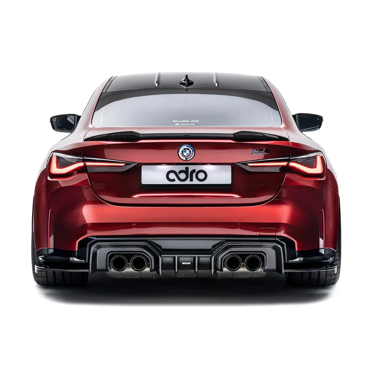 ADRO carbon fiber aero for BMW G22 M440i, rear view showing quad exhaust and ADRO plate on white background.