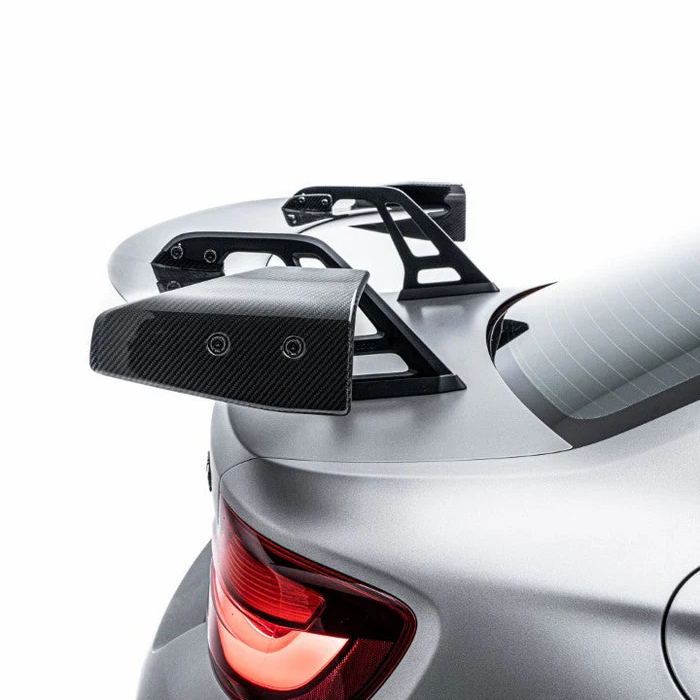 Silver-gray BMW M2 rear end detail with red taillight and carbon-fiber look spoiler