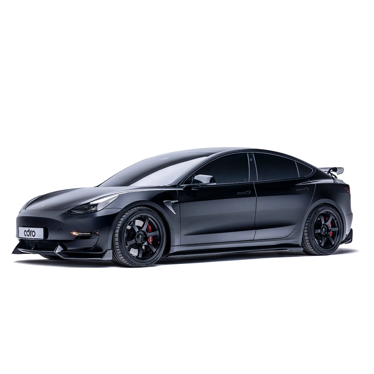 ADRO carbon fiber side camera covers on Tesla Model 3, installed view, black car on white background.