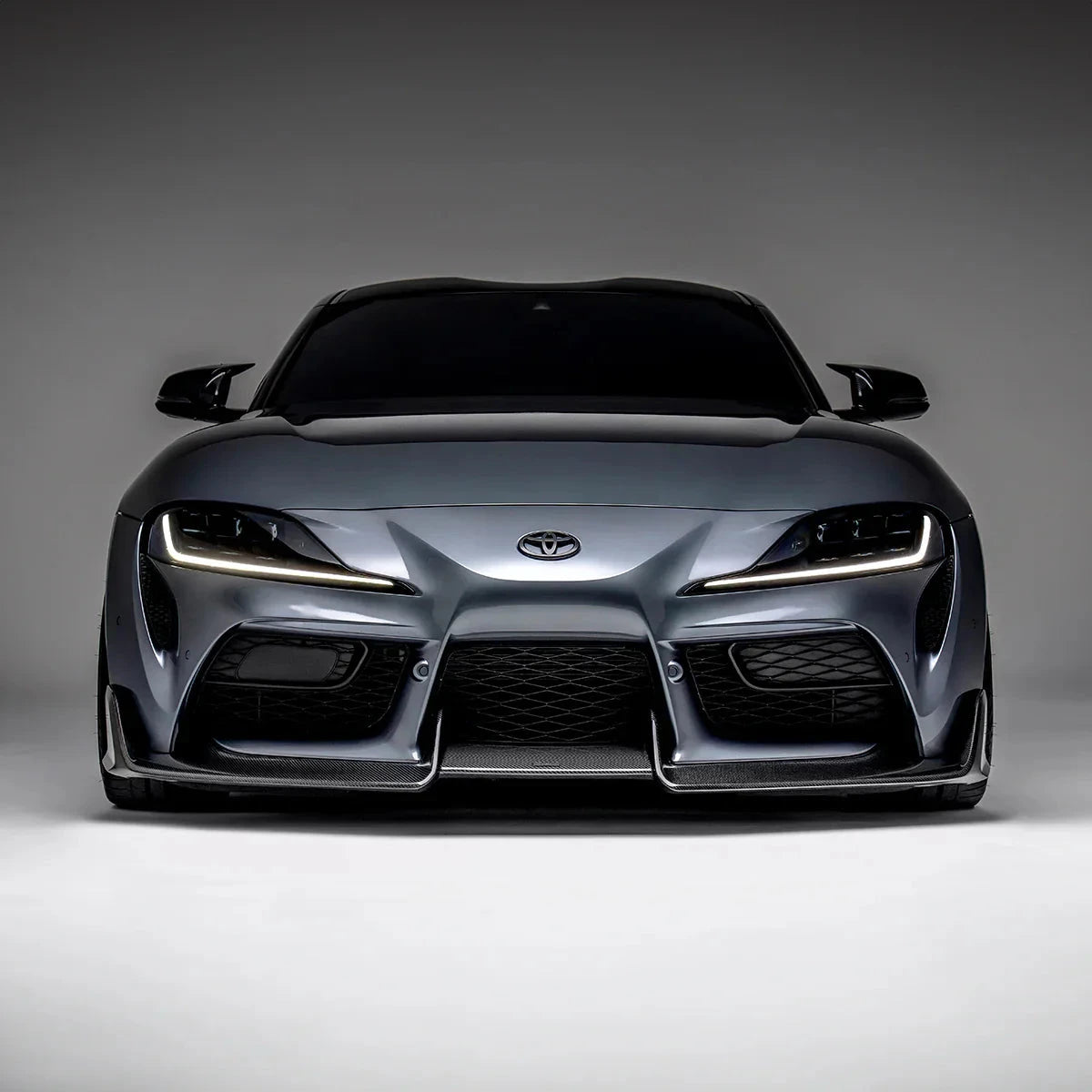 Toyota GR Supra carbon fiber front lip on stock front bumper, dark black