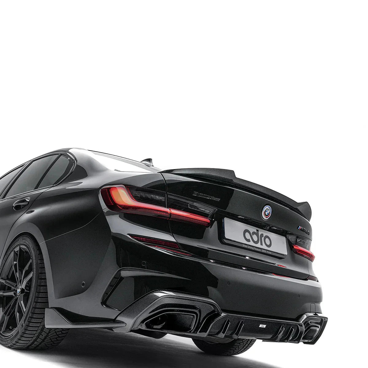ADRO carbon fiber rear diffuser for BMW G20 M340i, rear view with spoiler and slim tail lights visible.