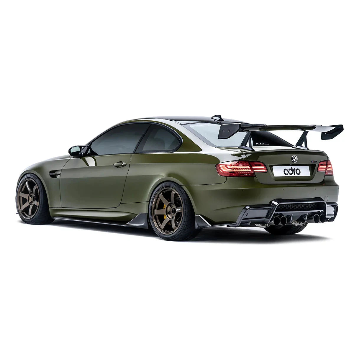ADRO rear wing on BMW E92 M3, rear left view with carbon fiber aero and bronze wheels visible.