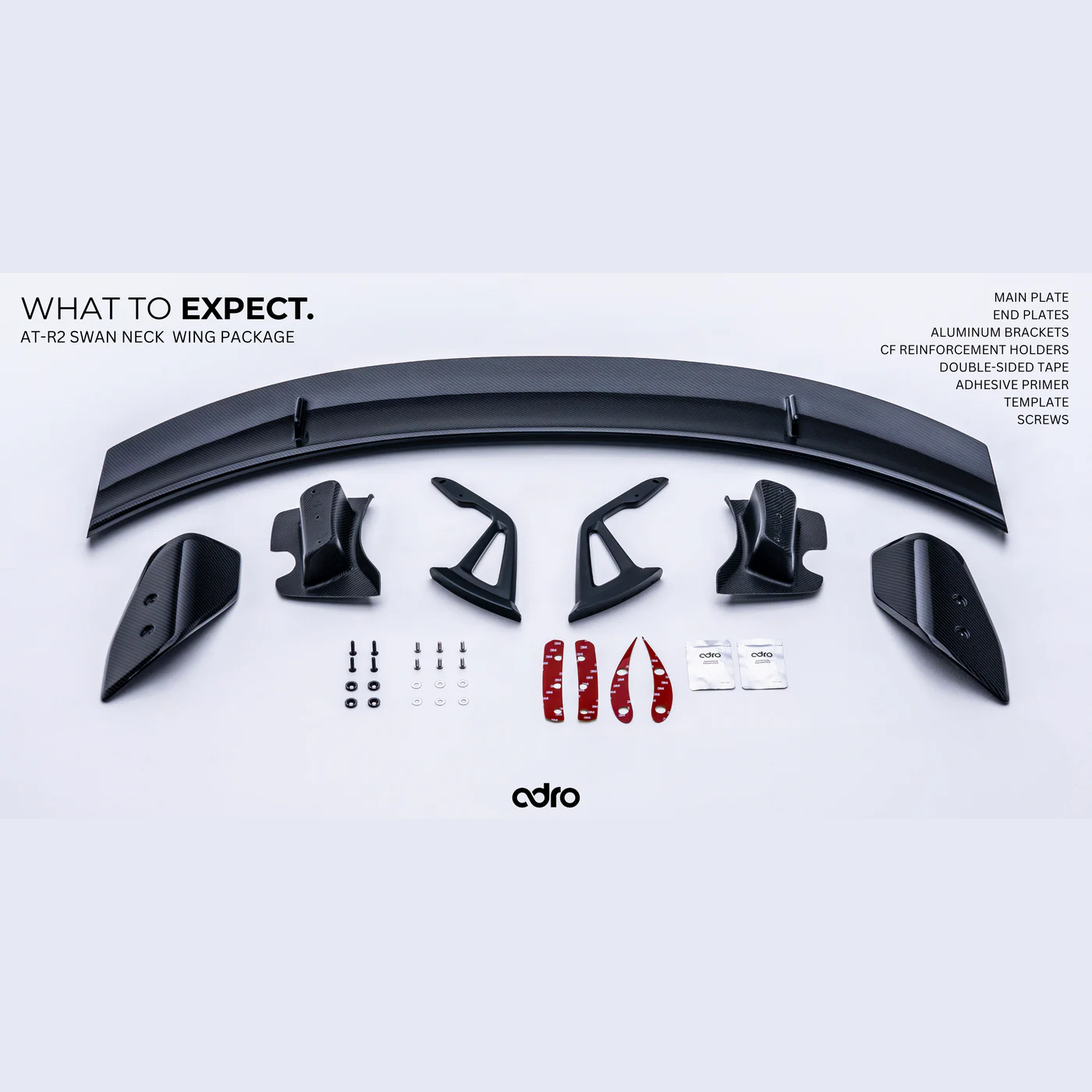 ADRO Toyota GR Supra AT-R2 Swan Neck Wing kit on white, showing carbon fiber plates, brackets, screws, and instructions.