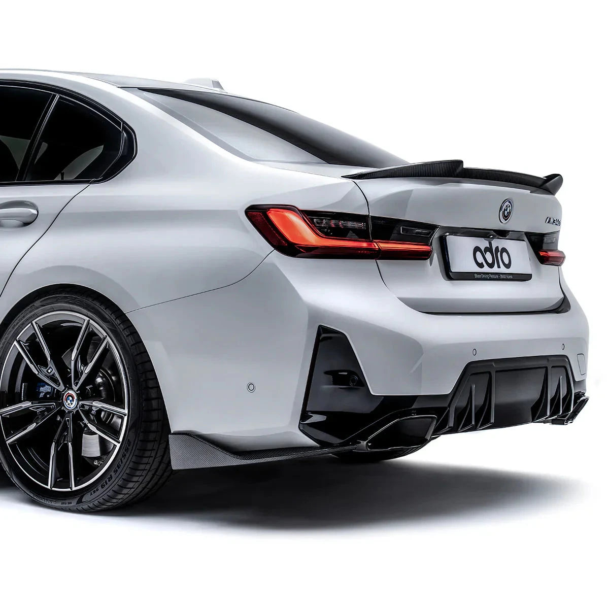 BMW M340i sedan rear quarter view with red taillights and black diffuser