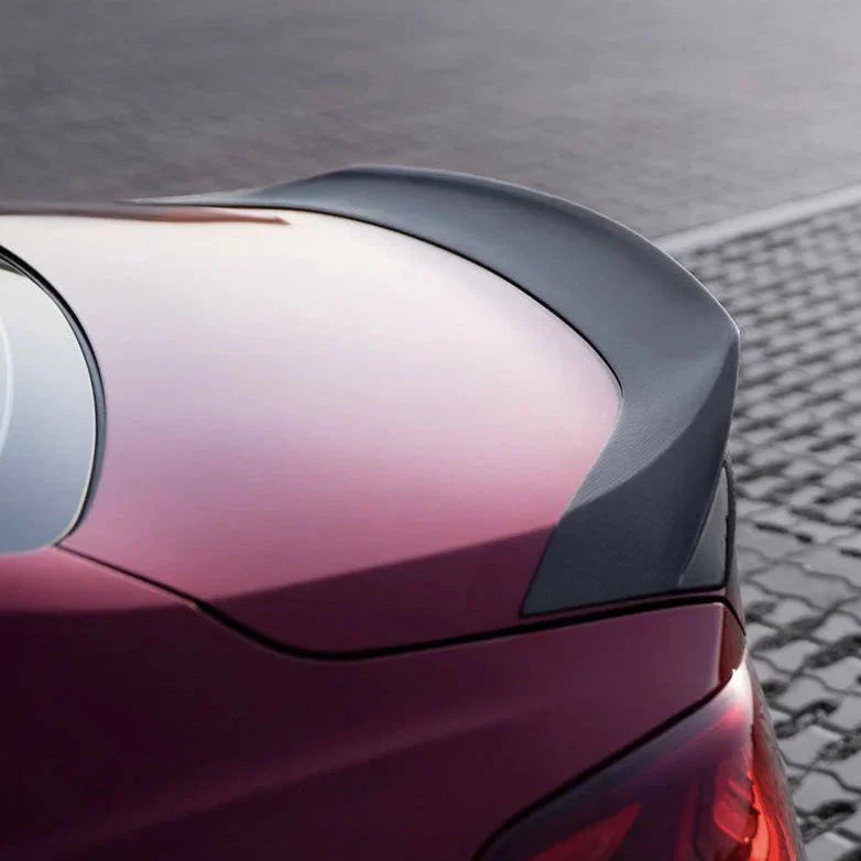 Purple-red sedan rear quarter close-up with tail lamp edge and curved panel line