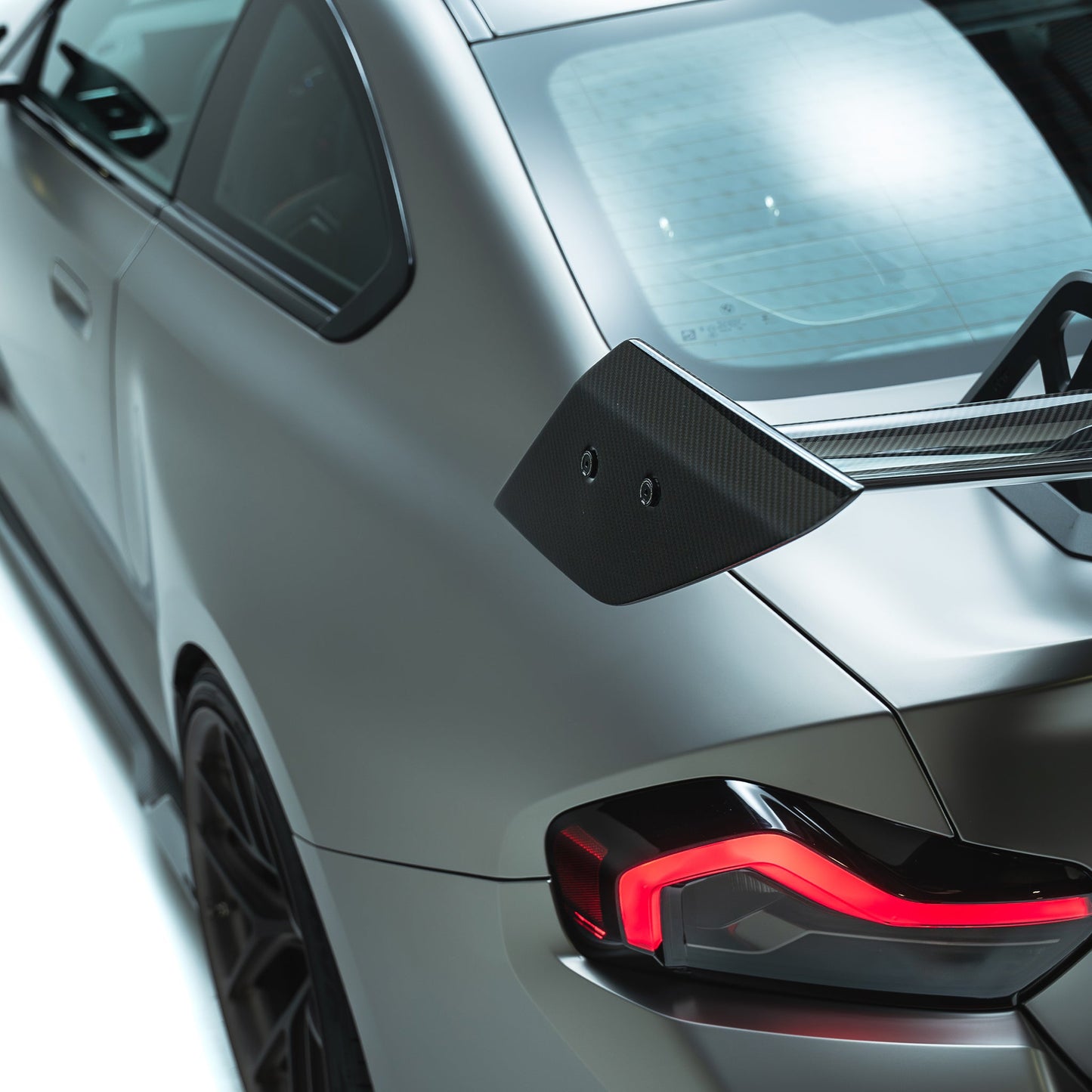 Carbon-style spoiler endplate on swan-neck support, black with screw holes