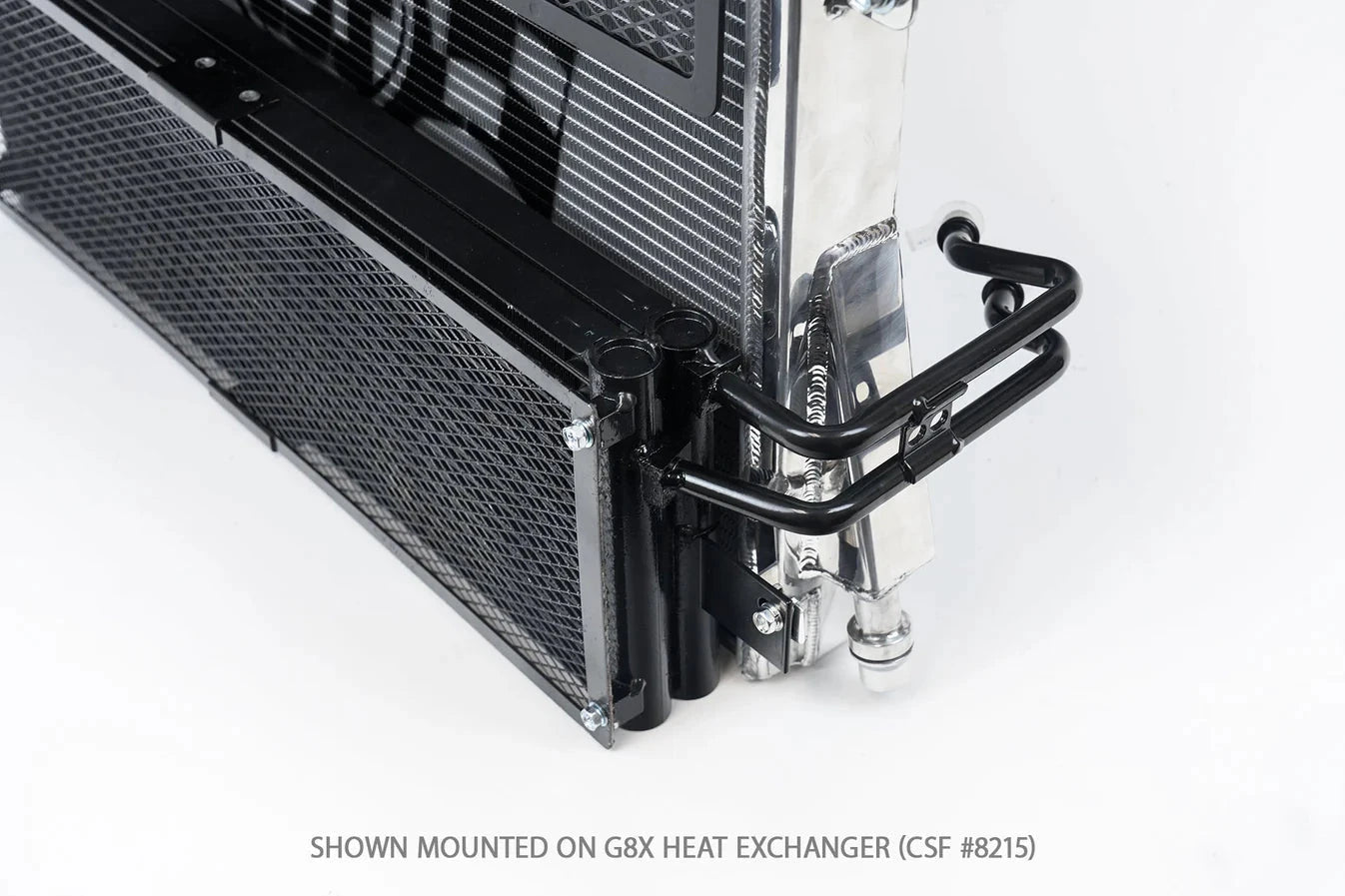 Corner detail of black transmission cooler mounted on heat exchanger with hose fittings.