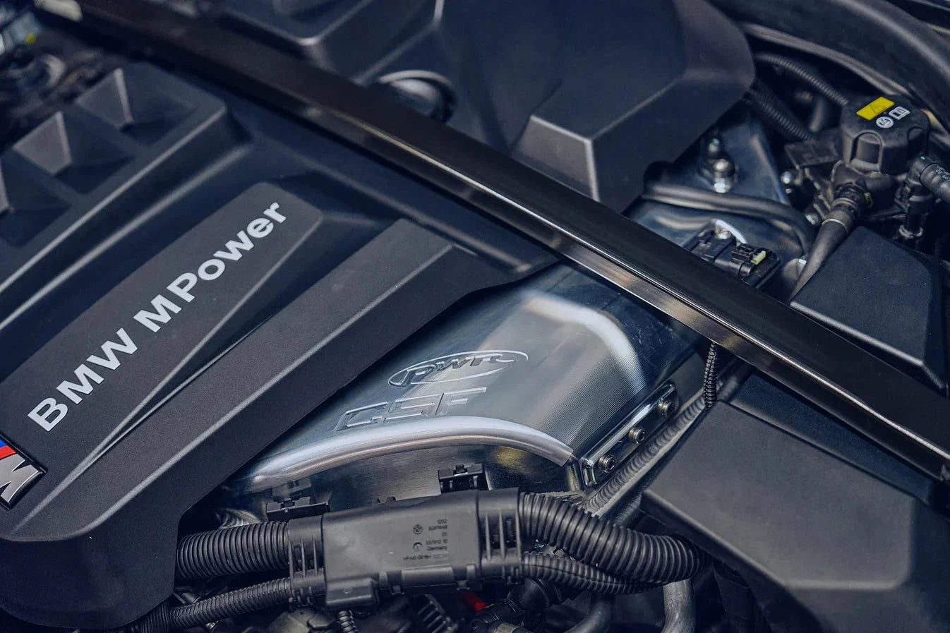 Charge-air cooler manifold installed with metal pipes and hoses in engine bay
