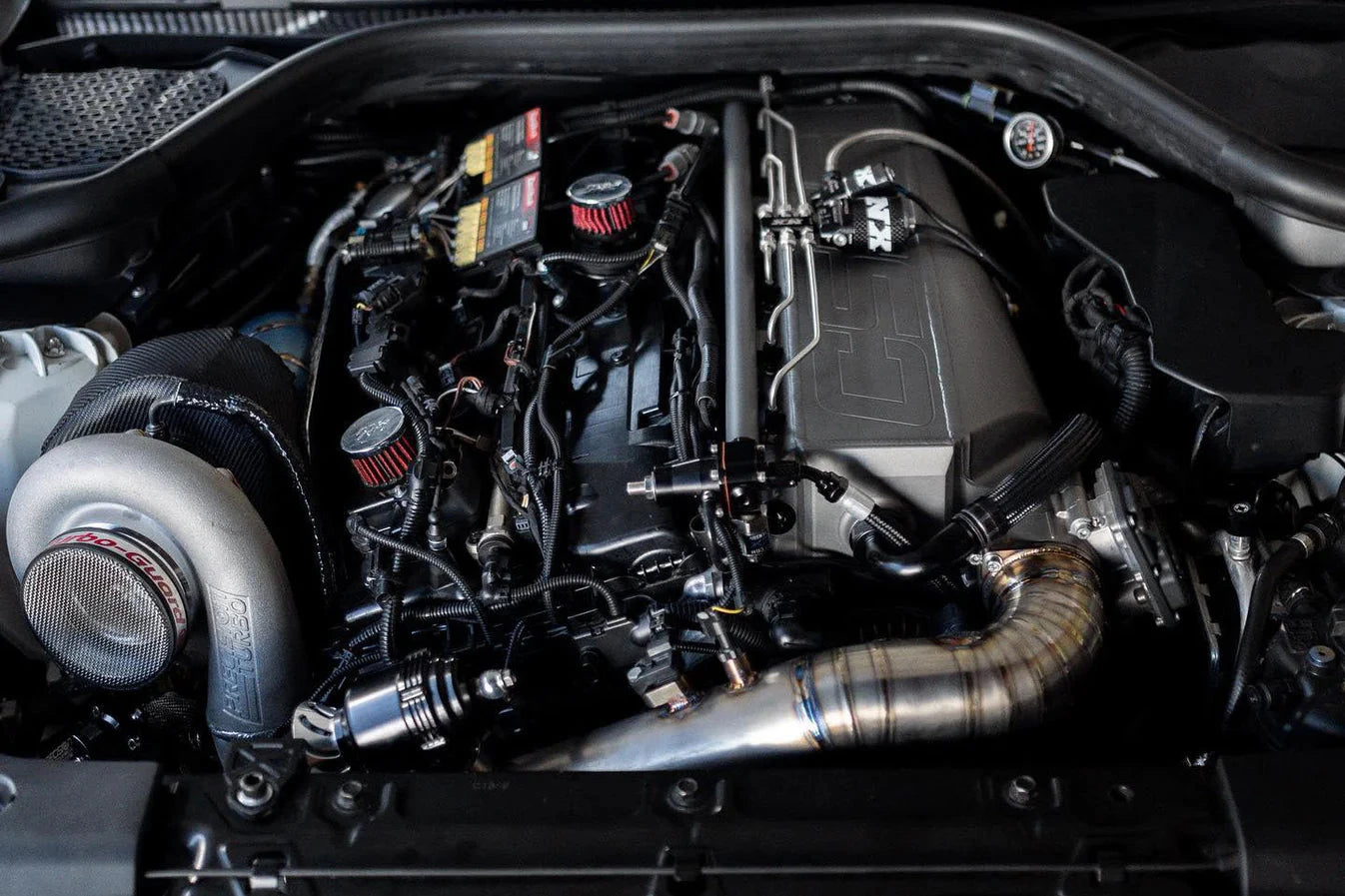 Engine bay charge-air manifold and piping with blue silicone couplers on engine