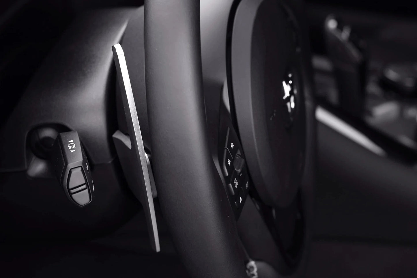 Black steering wheel paddle shifter with silver edge and button cluster