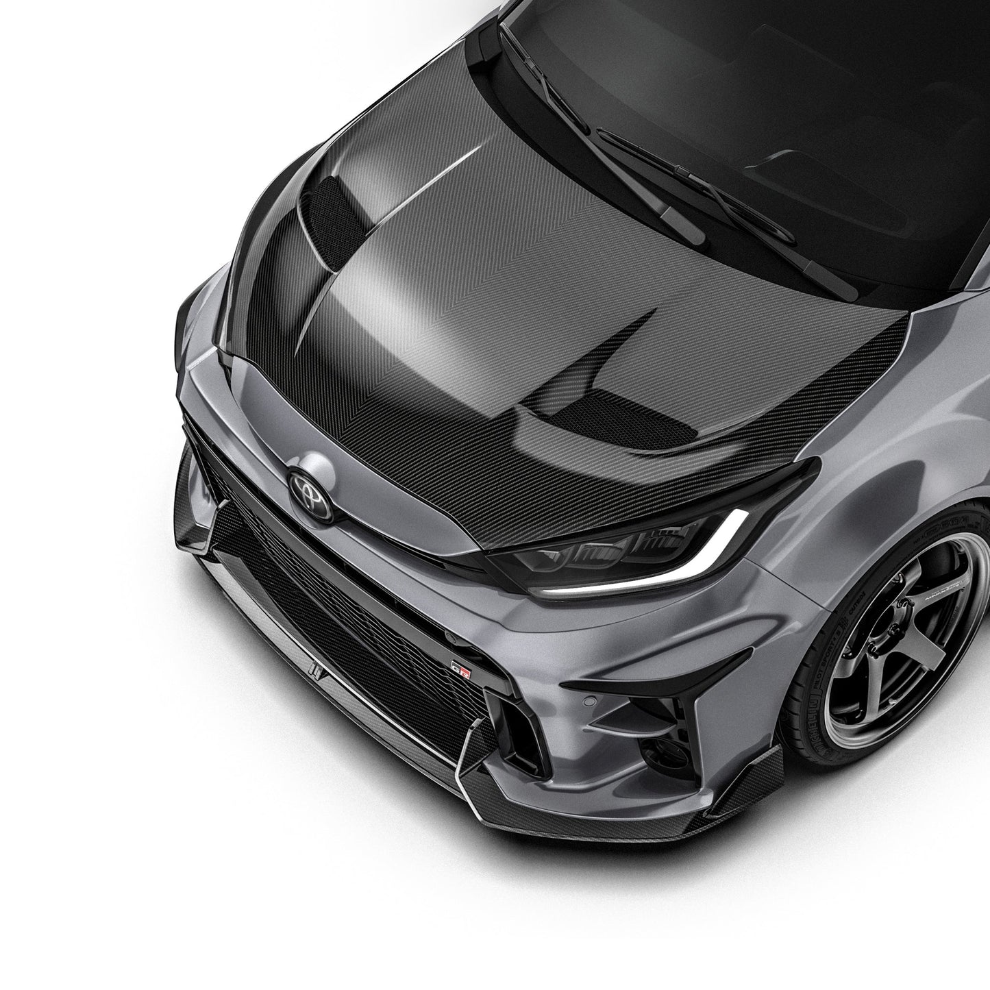 Carbon fiber front lip with dark woven texture, visible on the front bumper lower edge.