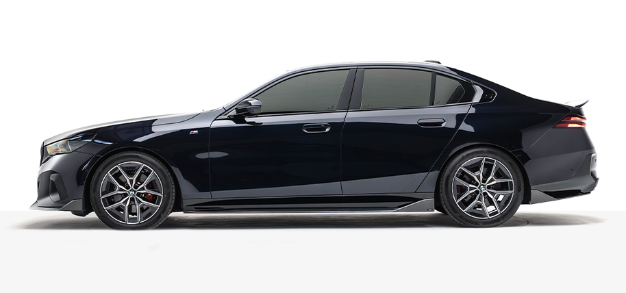 BMW G60 5-Series sedan, dark exterior, side view with alloy wheels