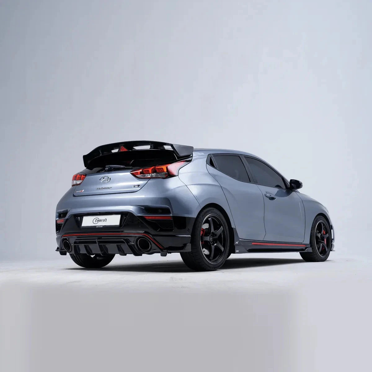 Hyundai Veloster N carbon fiber-style side skirt shown from rear 3/4, red trim
