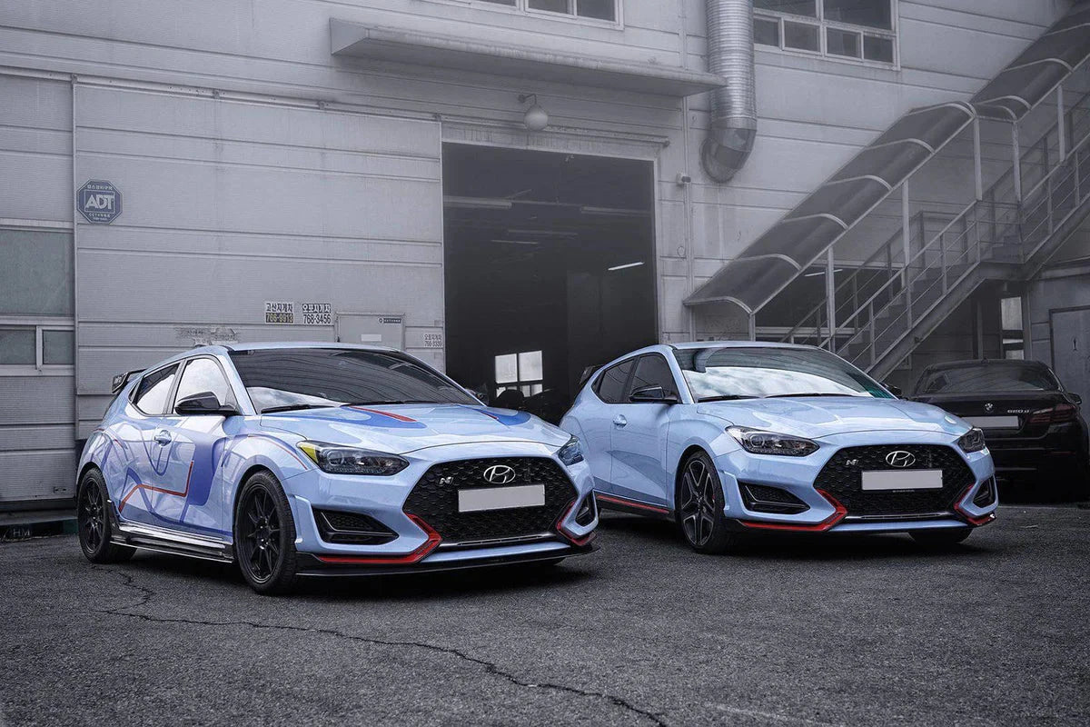 Pair of Hyundai hatchbacks with black carbon fiber front lip splitters