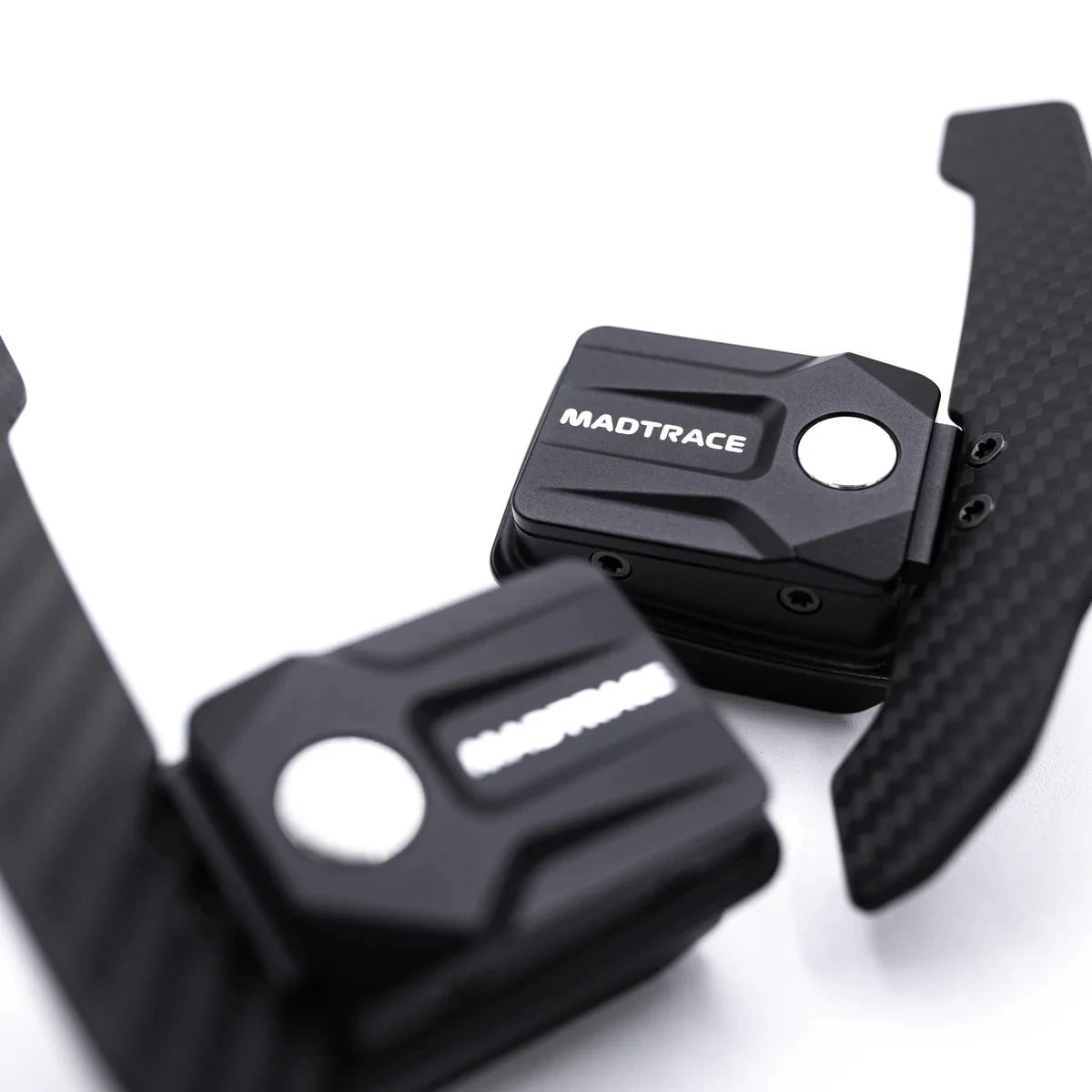 Magnetic paddle shifters close-up, MADTRACe logo on black paddles with carbon-fiber look