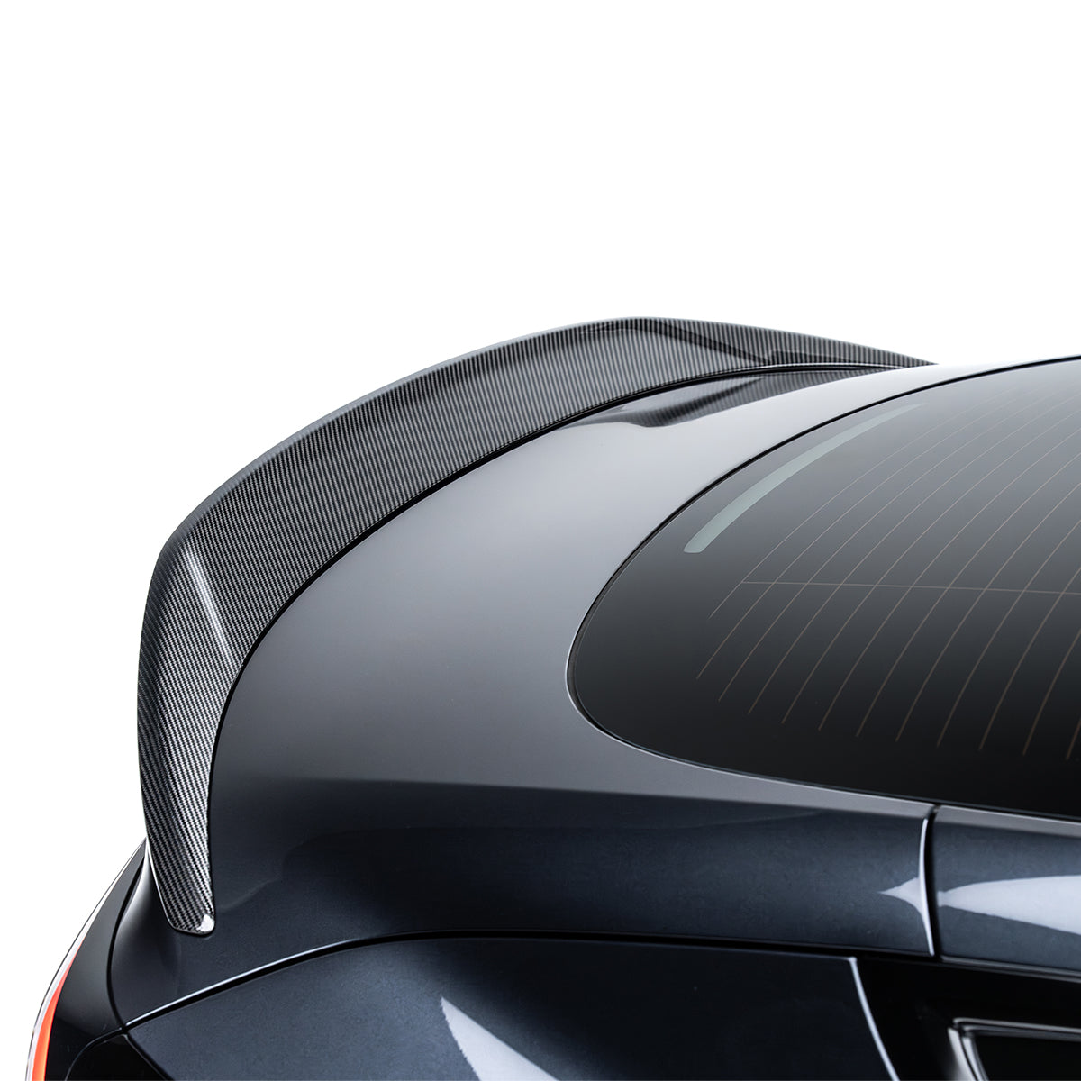 Black carbon fiber spoiler trim with fine weave texture near rear quarter on Tesla