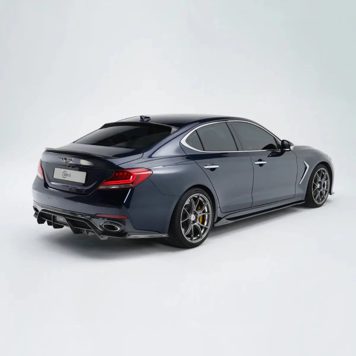 Dark gray performance sedan rear three-quarter view with alloy wheels and dual exhaust