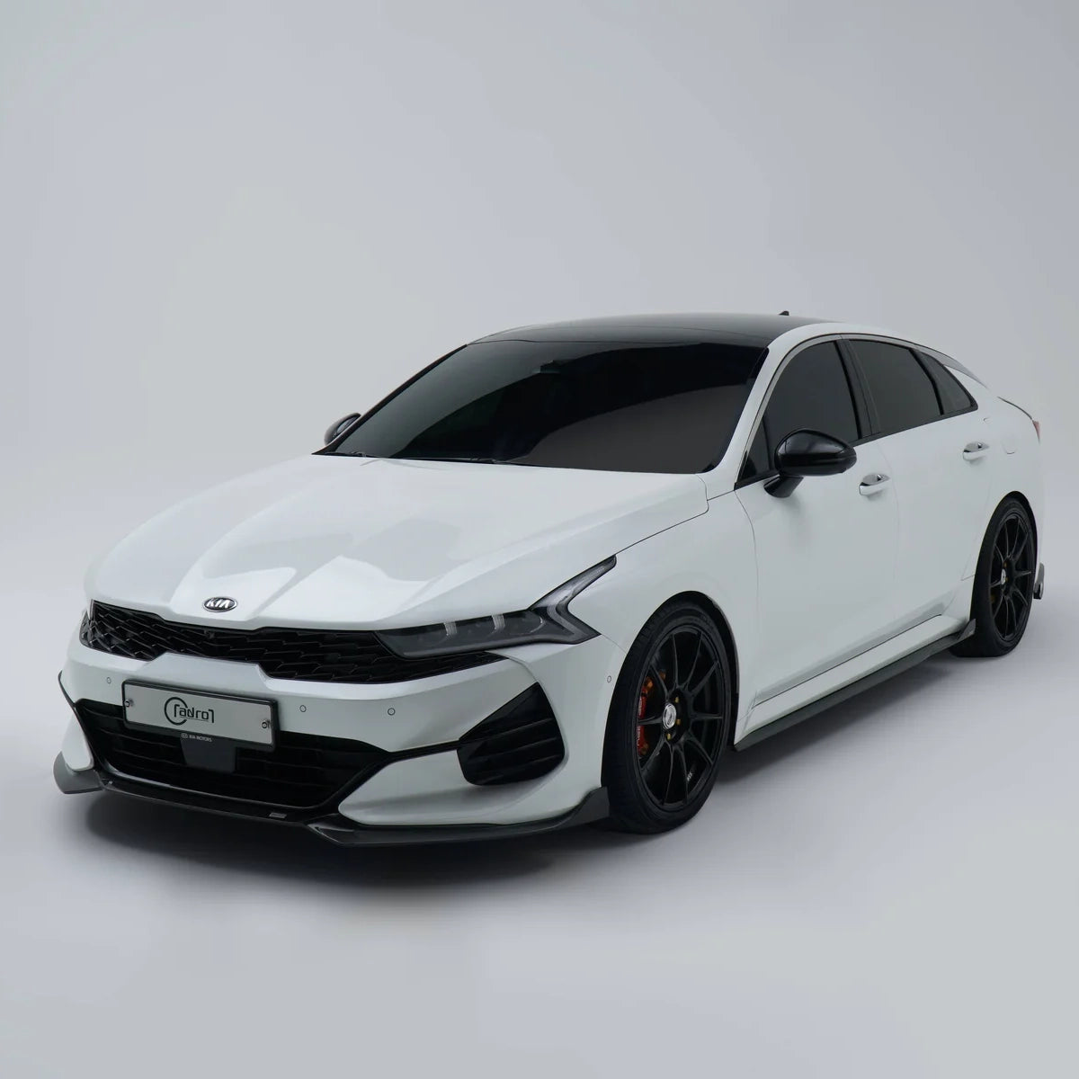 White sport sedan with front bumper, black grille, and dark wheels