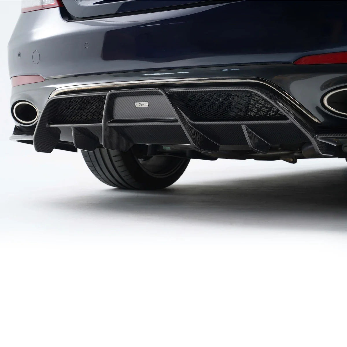 Rear bumper and exhaust area on a dark blue performance sedan with twin round outlets