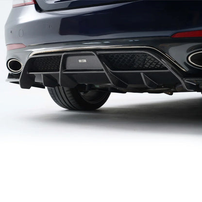 Rear bumper and exhaust area on a dark blue performance sedan with twin round outlets