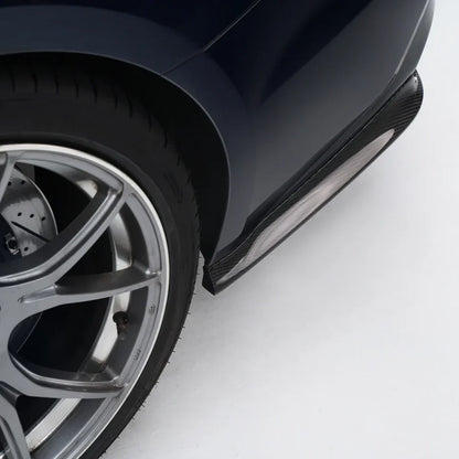 Dark blue performance sedan front wheel and side skirt detail with black rocker trim