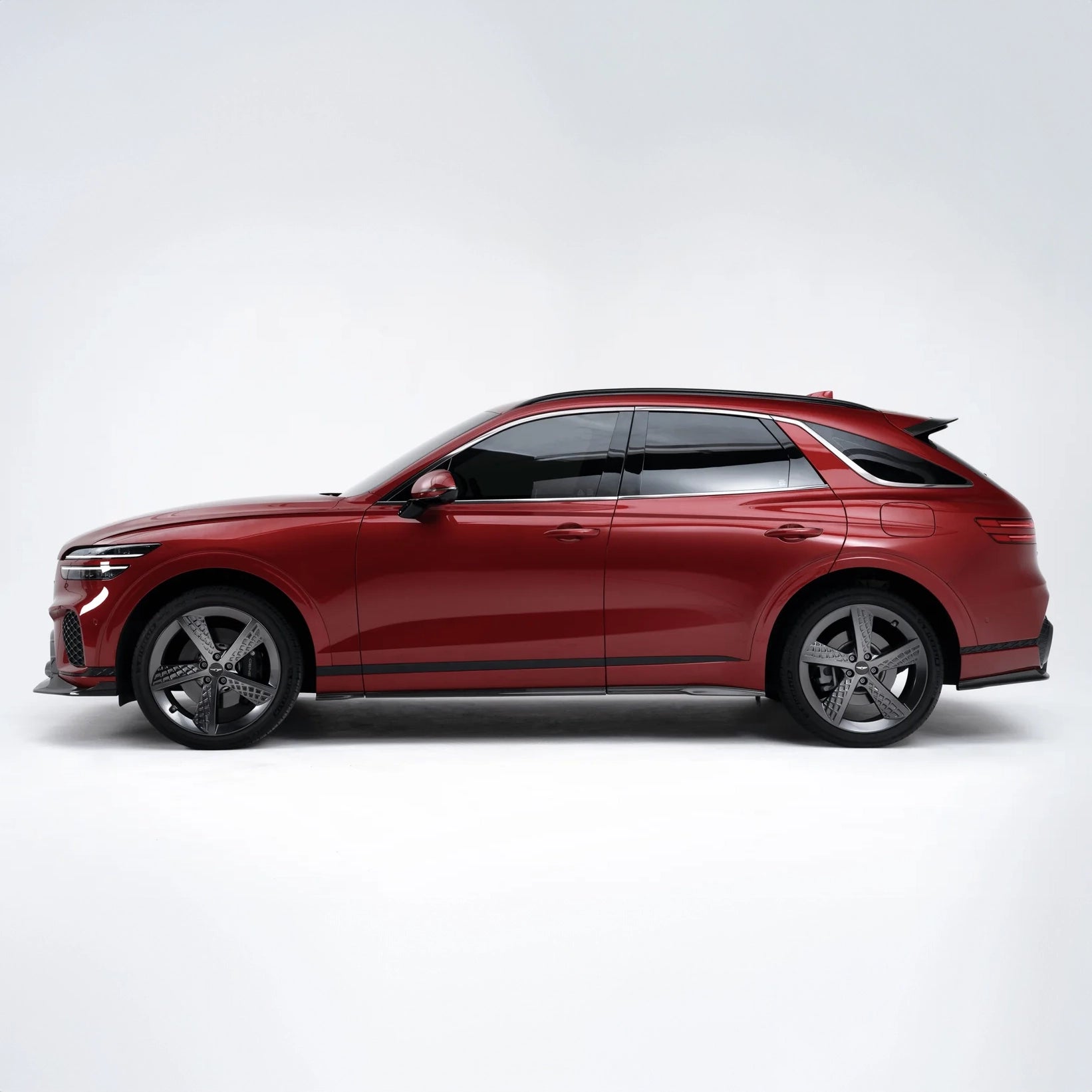 Red SUV, black wheels and side trim, tinted windows, profile view