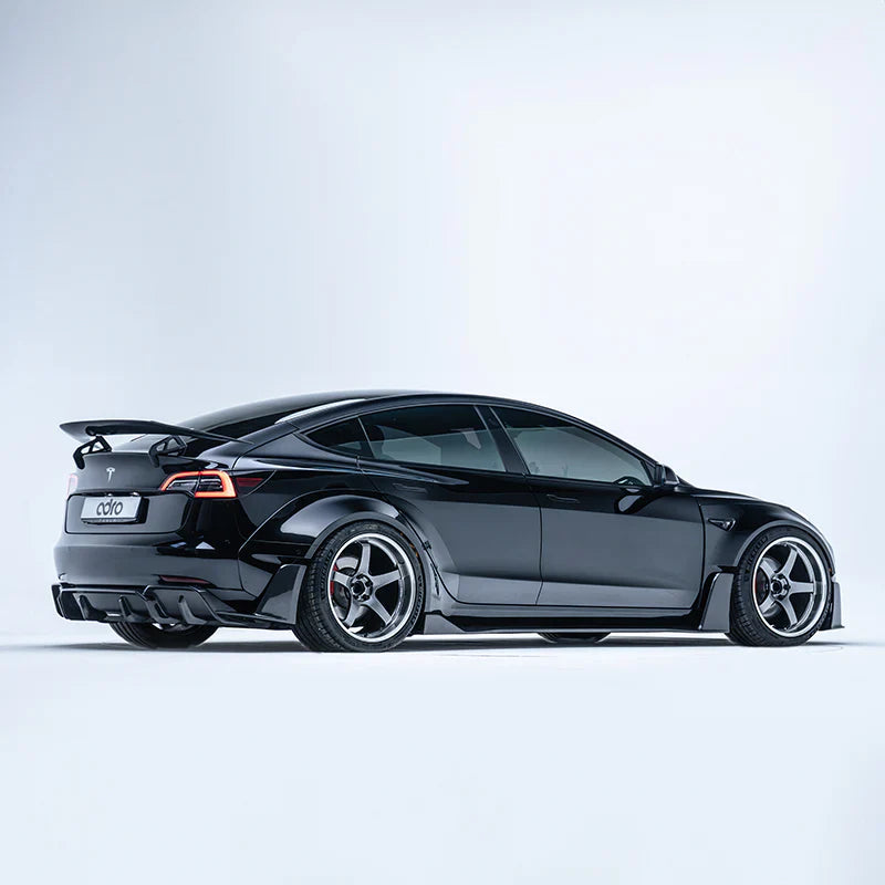 ADRO widebody kit for Tesla Model 3, installed view showing carbon fiber parts and rear spoiler.