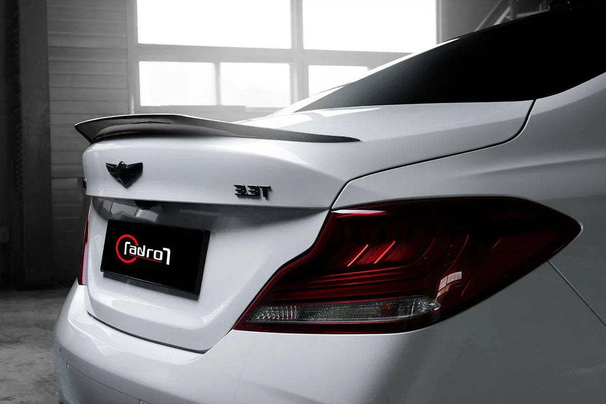 White performance sedan rear corner with taillight cluster and trunk spoiler