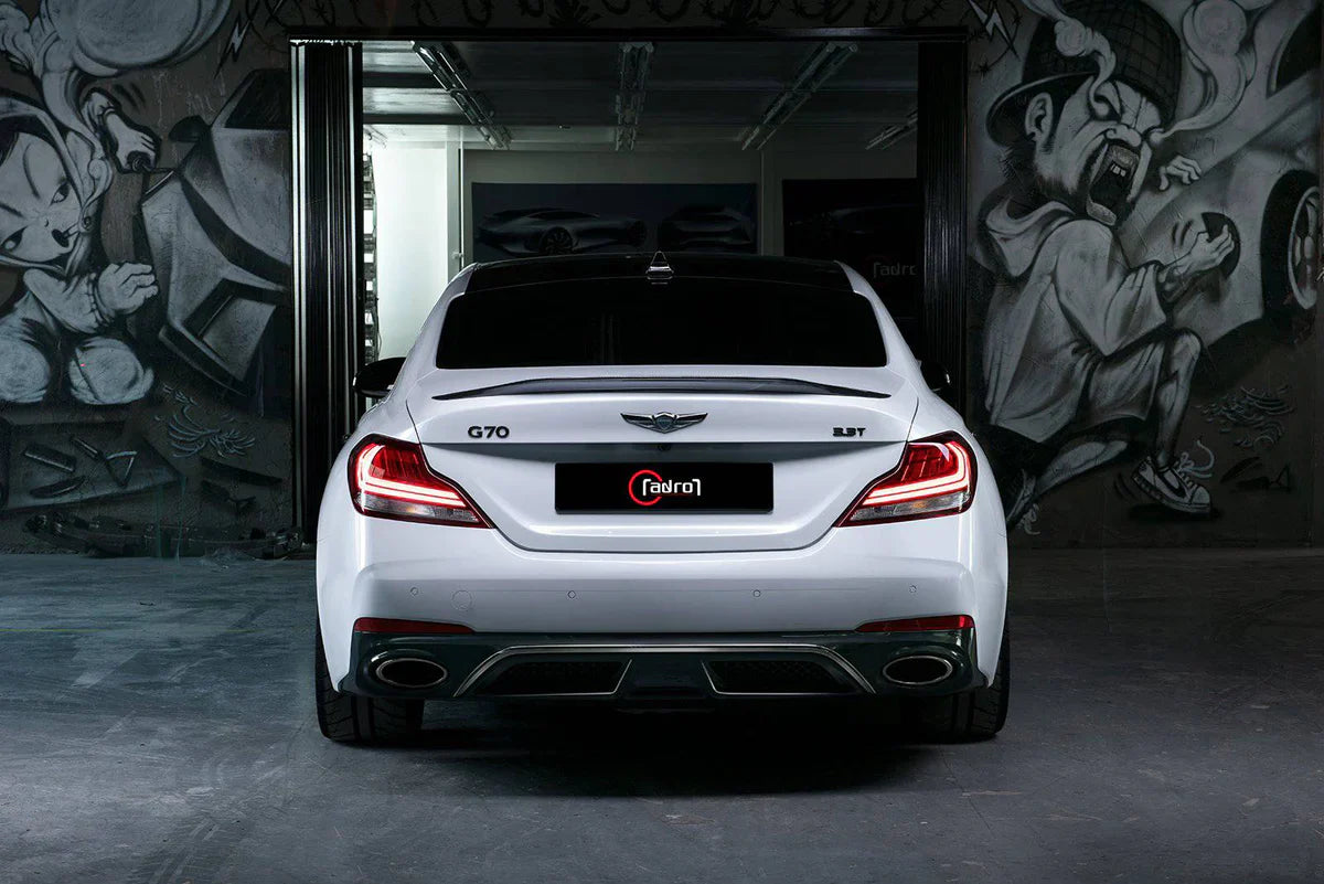 White performance sedan rear view with twin exhaust outlets and wide rear diffuser