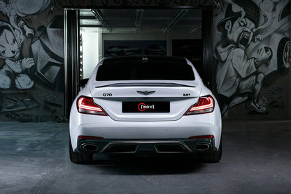 White performance sedan rear view with twin exhaust outlets and wide rear diffuser