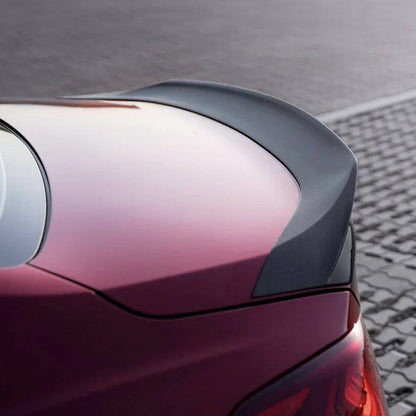 Purple-red sedan rear quarter close-up with tail lamp edge and curved panel line