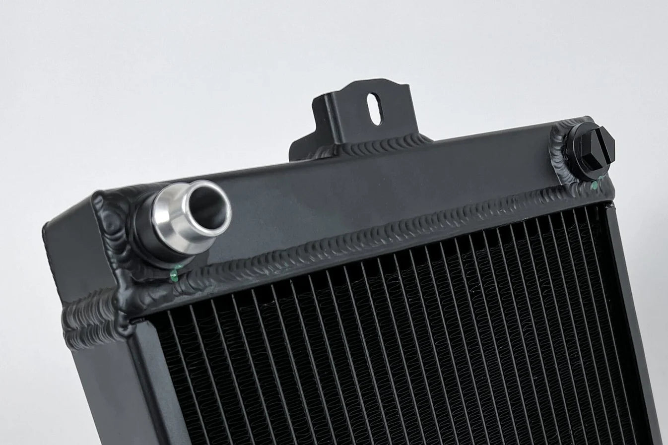 Auxiliary radiator with aluminum inlet fitting on black housing and fin core