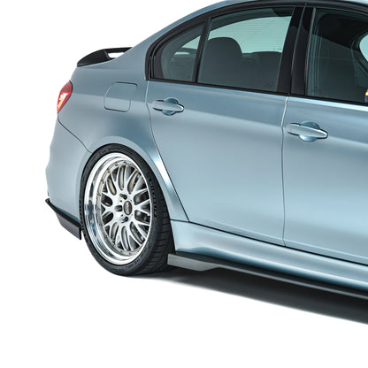 Carbon fiber side skirts, dark rocker-panel trim on light blue sedan side.