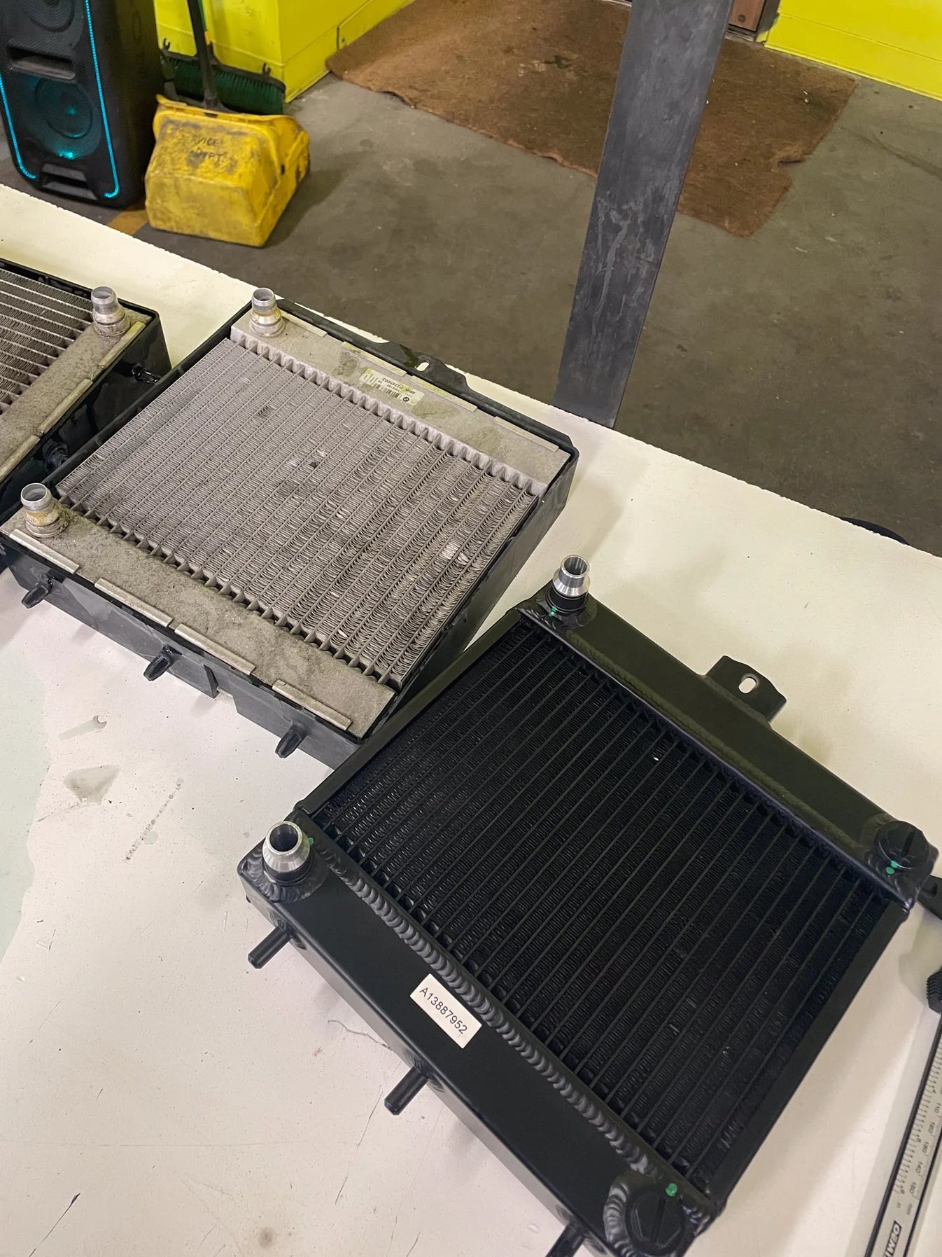 Auxiliary radiator installed in engine bay, black mesh core with mounting hardware