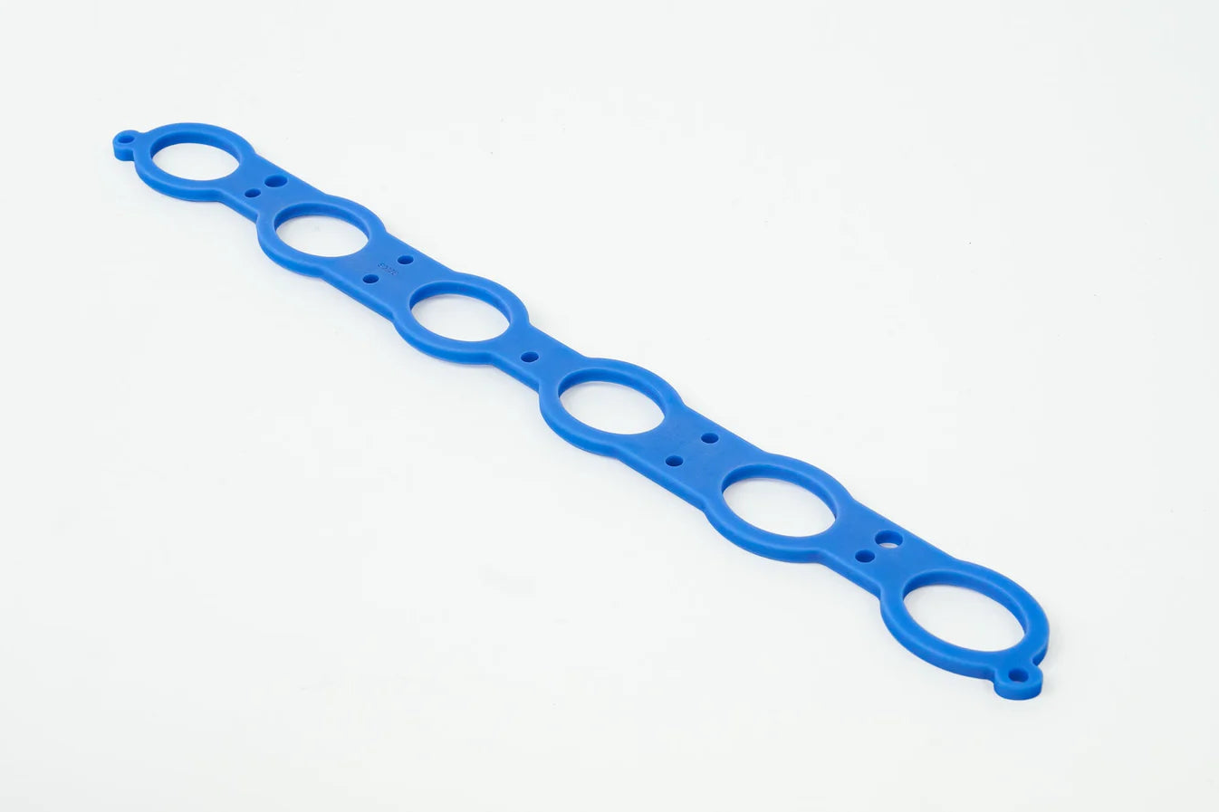 Blue manifold spacer gasket strip with circular ports along the length