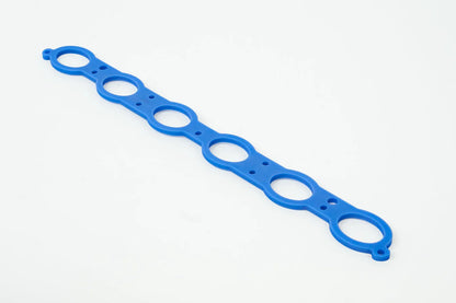 Blue manifold spacer gasket strip with circular ports along the length