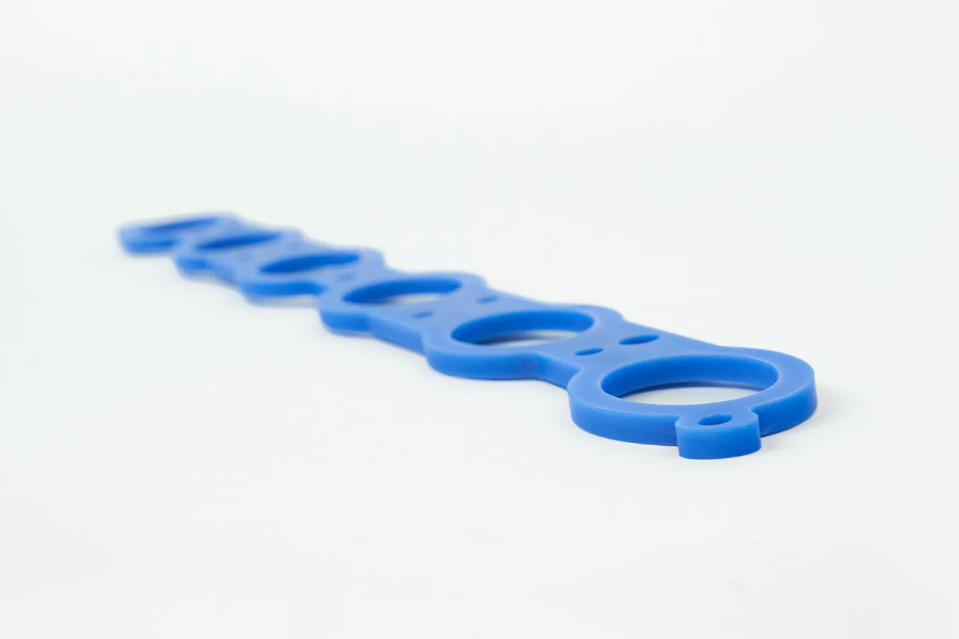 Blue manifold spacer gasket strip, long shape with evenly spaced round holes