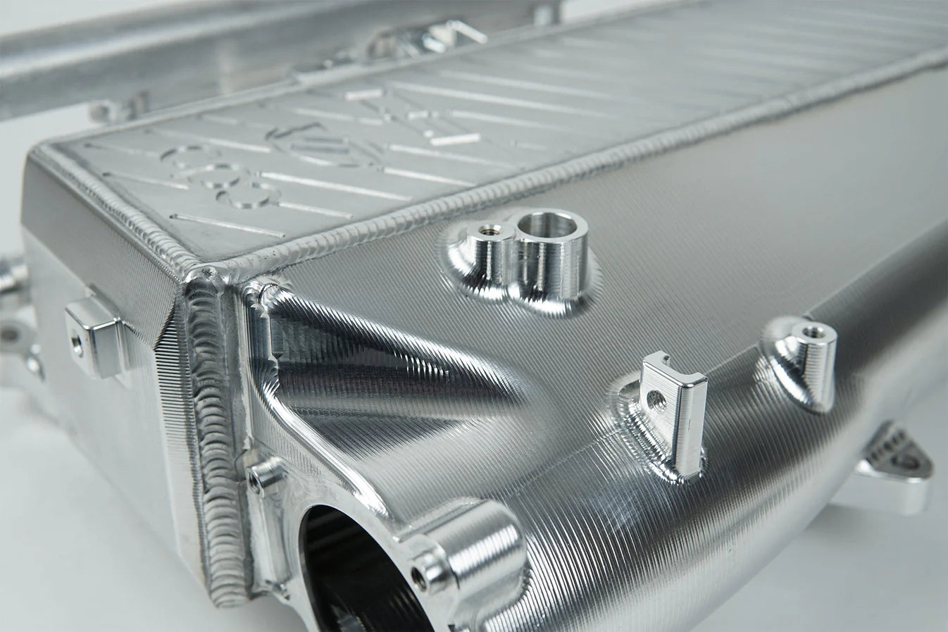 Charge-air cooler manifold, silver side view with embossed panels and outlet inlet fittings