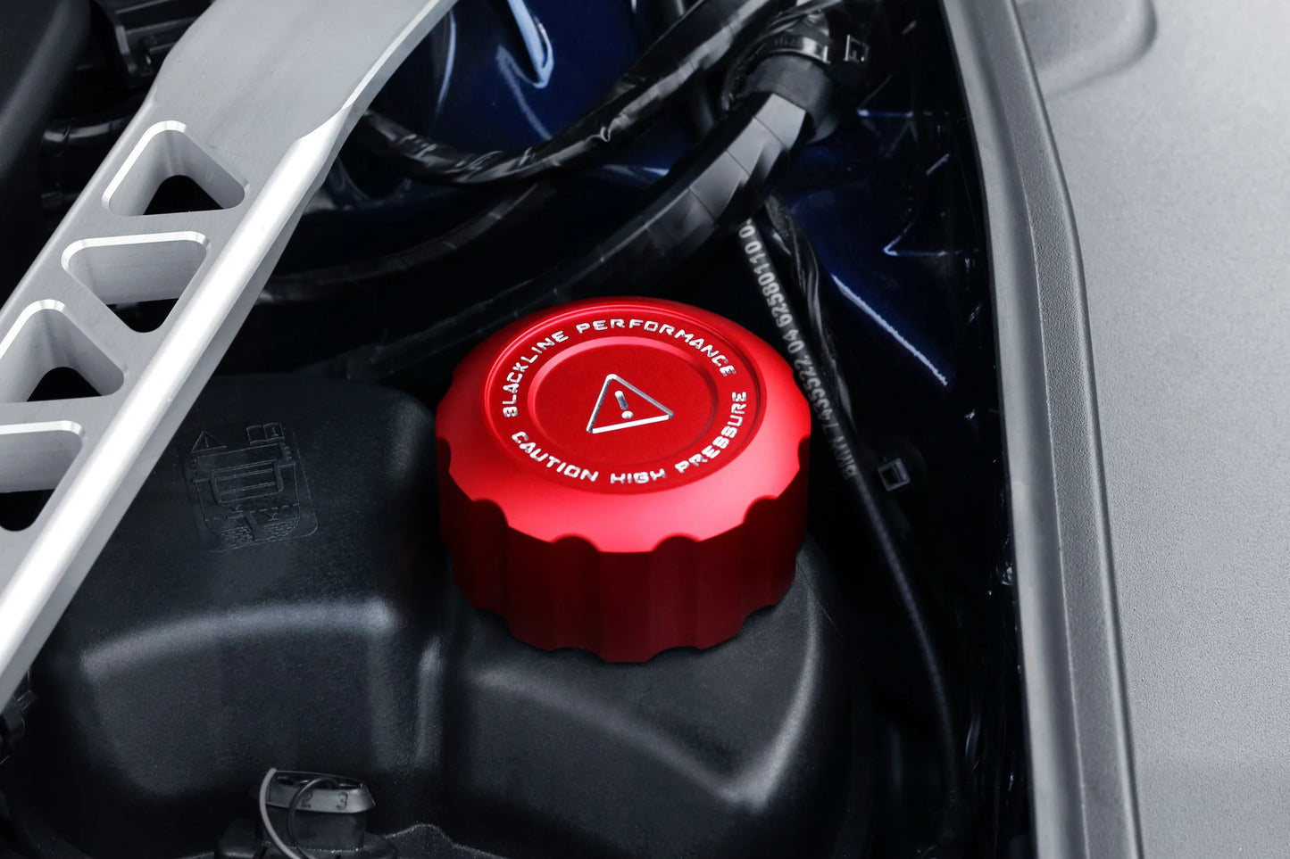 Coolant cap cover set: red cap cover placed on a black engine cover area