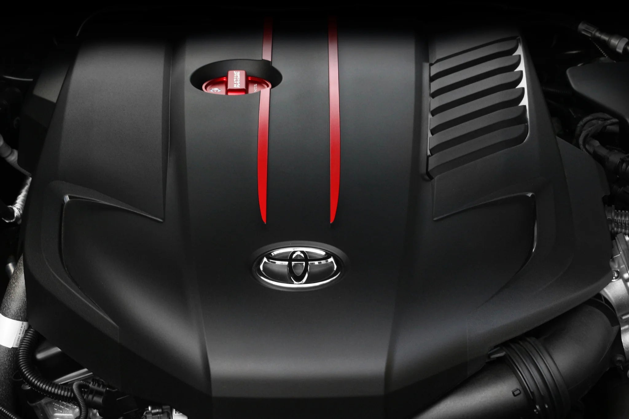 Red oil cap cover with BLACKLINE text on black engine cover