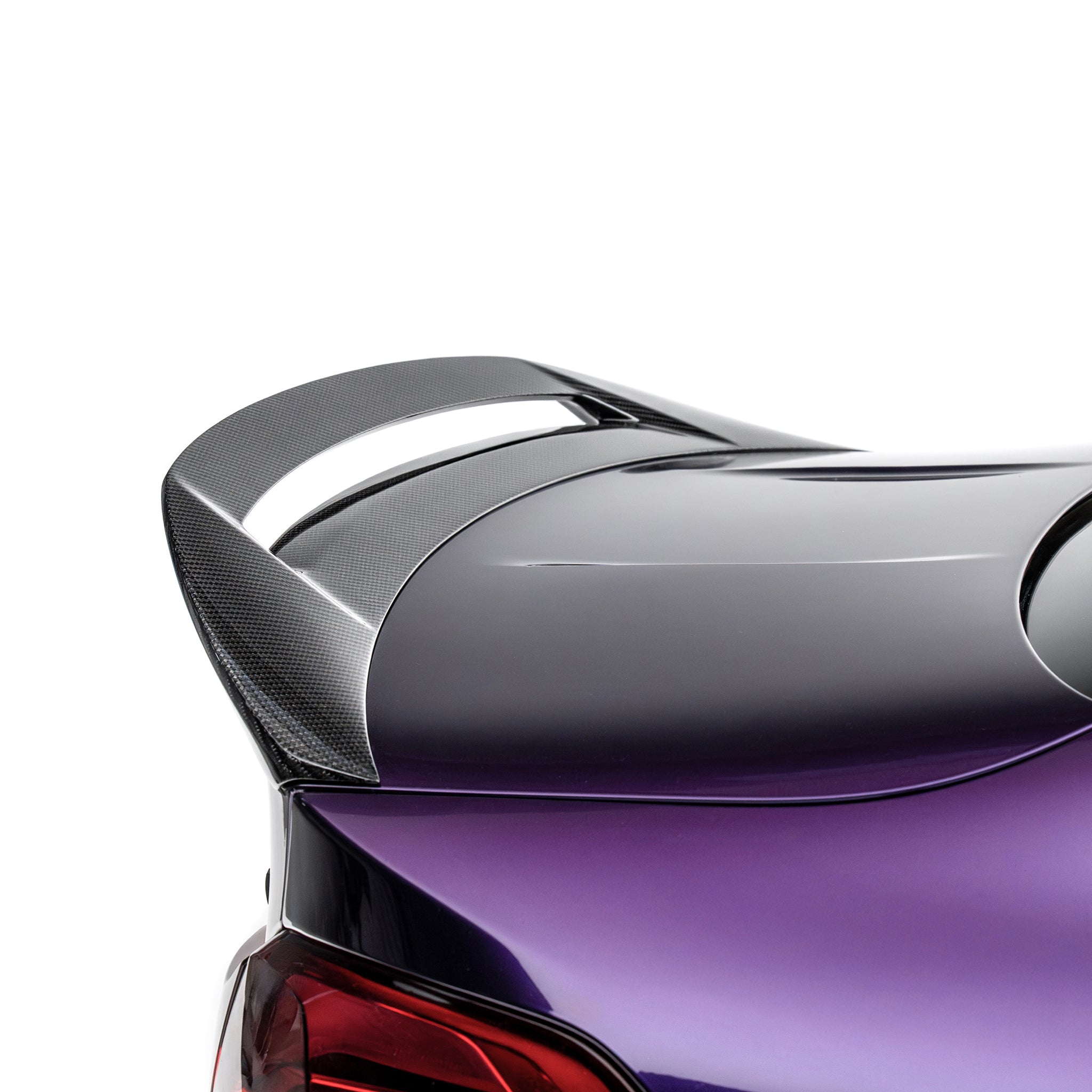 Carbon-fiber rear spoiler with raised lip on a purple coupe