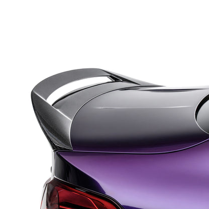 Carbon-fiber rear spoiler with raised lip on a purple coupe