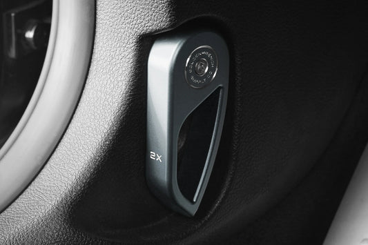 Hood latch handle cover, dark gray with handle slot and '2x' marking