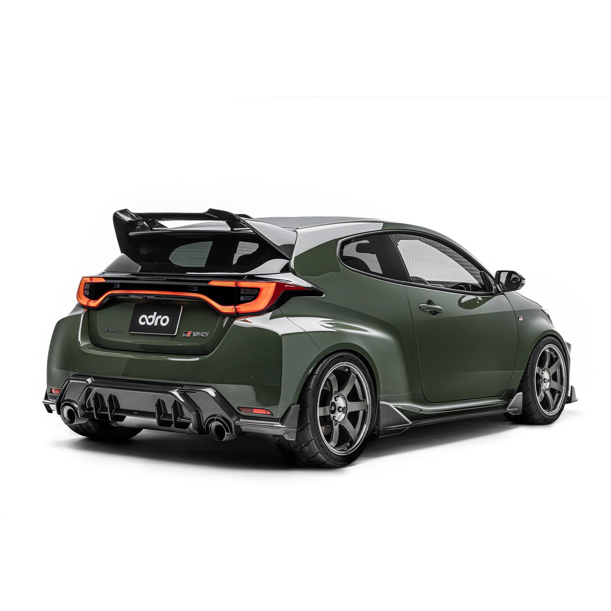 ADRO carbon fiber rear diffuser for Toyota GR Yaris, installed view, matte green car with black wheels and large wing.