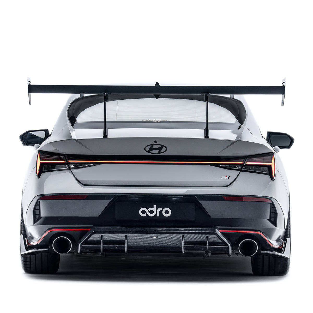 Rear diffuser insert, dark grille panel with dual exhaust openings and red trim accents