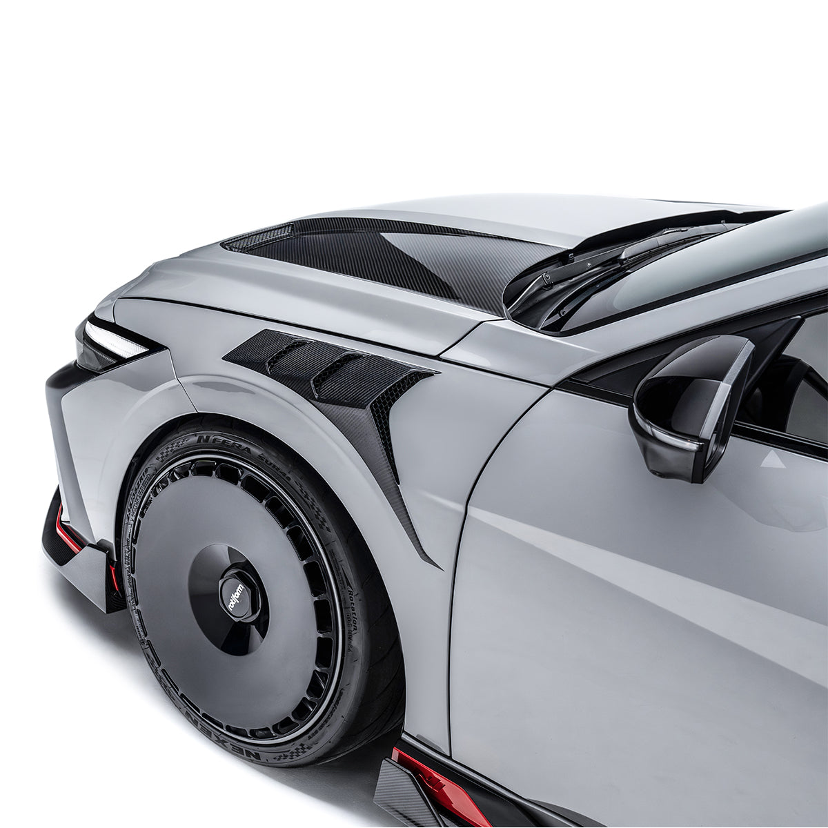 Carbon fiber front fender with black weave accents along wheel arch