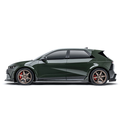 Carbon-fiber style side skirts with black finish and silver edge trim on a green car