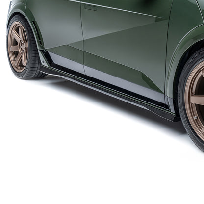 Black carbon-fiber style side skirt with textured weave and silver accent stripe